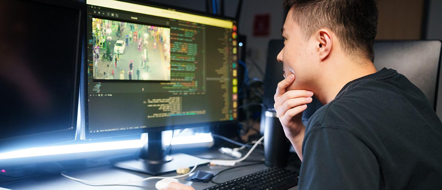 A young man looking at a computer screen