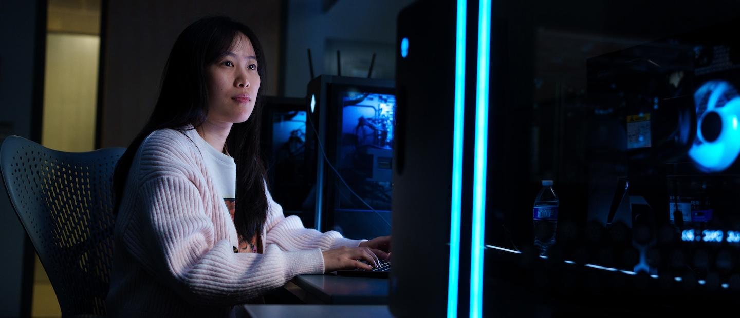 A woman in a dark computer lab